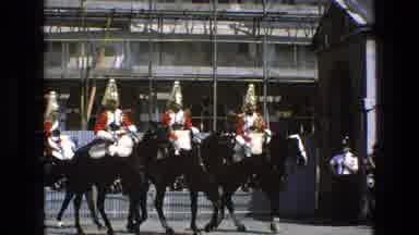 England-1969: Men In Red Uniforms With Gold Helmets Riding Black Horses In Formation