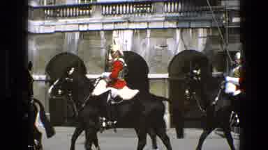 England (1969): Guards Wearing Red And Black Uniforms Ride Black Horses On A
