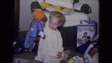 Fort Wayne Indiana (1969): A Blonde Toddler Dressed In A Sleeping Gown Plays With
