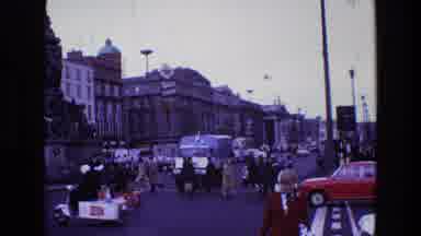 Ireland (1969): People Cross Between The Many Cars And Trucks Of A Busy