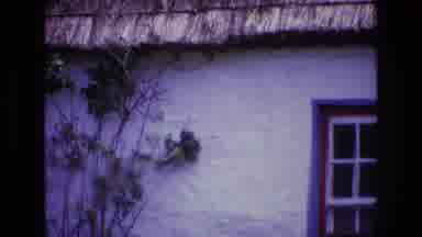 Ireland (1969): White House That Has A Thatched Roof With A Blue And Red Framed