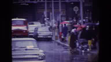 Ireland (1969): Old Classic Cars Drive Down Busy City Street In Rainy Weather