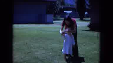 White Sands Florida-1970: Woman Helps Child Make Peace Sign In Backyard