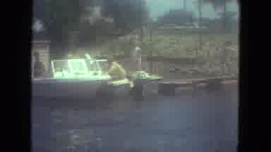 Mississippi (1971): Three People Are Standing Around A Small Docked Fishing Boat