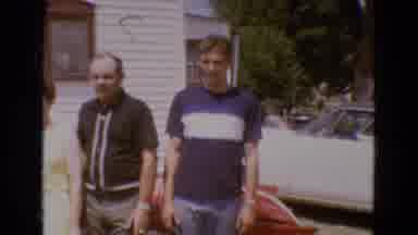Diller Nebraska USA (1968): Family Of Four Outside Man In Black Shirt Jumps At The