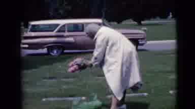 Clarksdale Arizona (1968): Older Woman Unwrapping A Pink Flower Arrangement To Lay