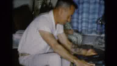 Clarksdale Arizona USA (1968): A Tattooed Man Opens A Present By The Christmas