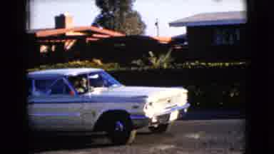 Clarksdale Arizona USA (1968): Old White Car Backing Out Of Driveway In A