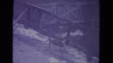 RACINE WISCONSIN USA-1972: Small Dog Sniffing Fence Line Tail Down vs Big Dog
