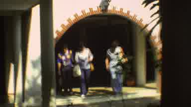 Mexico City (1973): Three People In 70s Clothes Walk Out Of A Building Smiling