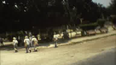Mexico City (1973): Some Men Walking Pass A Straw House Looking Around