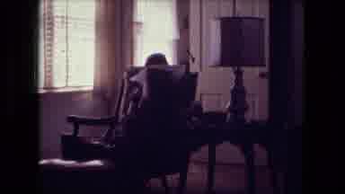 Fort Wayne Indiana (1974): Woman Sit In Chairs Followed By A Man Walking Outside