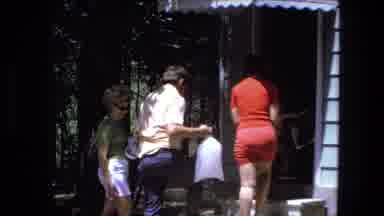 Fort Wayne Indiana (1974): Adults Carrying Bags Of Ice And Coolers Inside A House