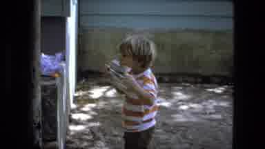 Fort Wayne Indiana (1974): Male White Child Playing Standing Putting An Object In