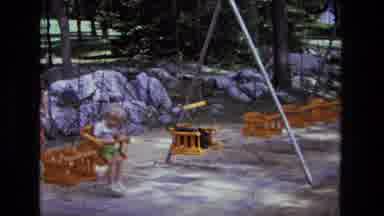 California USA (1975): Mamae Pushing Her Son On Swing On Playground In A 5-Second