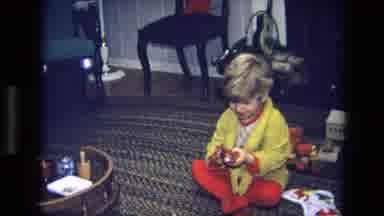 California USA (1975): Boy Opens A Box And Shows The Contents To His Father