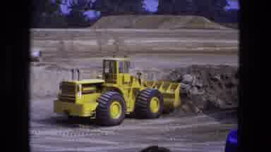 Fort Wayne Indiana (1974): Yellow Bulldozer Picks Up Load Of Sand On A Clear Day