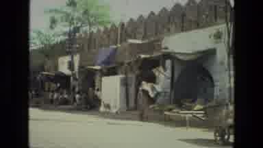 India (1974): A Lady On Open Road Working For Her Daily Routine Behind Traffic