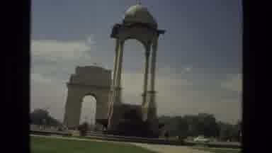 India (1974): A Pair Of White Archways And A Snake Charmer On A Sunny Day