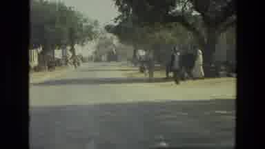 India (1974): Passing View Of Cemetery And People Walking Alongside Of Road On A