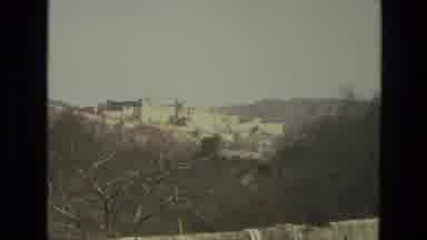 India (1974): A Distant Concrete City On A Hillside With Trees In The Foreground