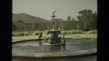 India (1974): Water Fountain In The Middle Of A Garden And Then We See Two People