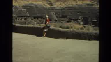 India (1974): Camera Pans To The Right By Lady In Red In A Field