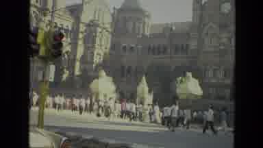 India (1974): Many People Walking Near A Cathedral And A Highway