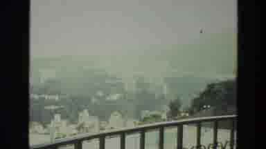 India (1974): The View From The Balcony Of A Building On A Hill Is Of A City