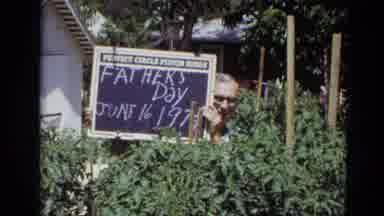 Lincoln Nebraska (1974): Old Man Holding Sign That Says Fathers Day While Two Old