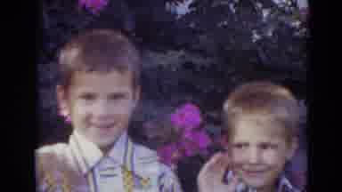 Lincoln Nebraska (1974): Two Boys In Dress Shirts Stand And Waive In Front Of Some