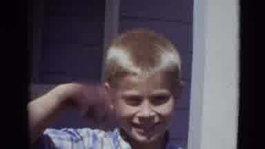 Lincoln Nebraska (1974): A Young Boy Waves To The Camera While Smiling