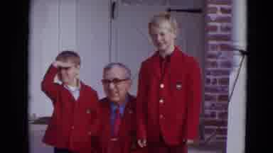 Lincoln Nebraska (1974): Man Kneels Down To Two Boys Level To Wave At Camera