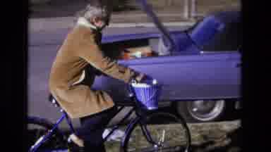 California USA (1975): Happy Woman Wearing A Long Coat Riding A Blue Bicycle With