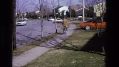 California USA (1975): A Person Riding Down The Street On Their Bike
