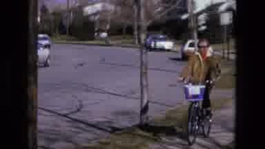 California USA (1975): Woman Walks Down The Sidewalk With Her Bicycle On Typical