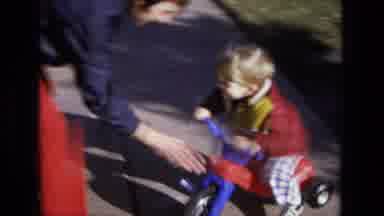 California USA (1975): Child Playing Outside His Home Accompanied By His Parents