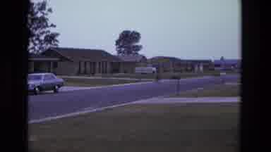 California USA (1975): Person Riding Bike Down Quiet Street