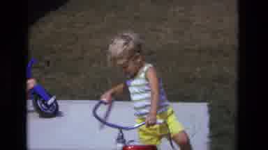 California USA (1975): Child Plays With His Toy Outside His Home On A Sunny And