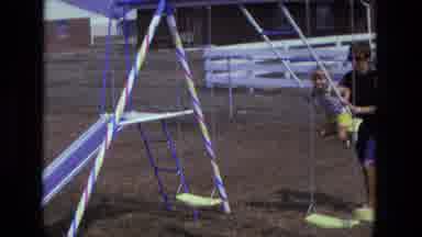California USA (1975): Woman Pushing Child On Swing