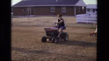 California USA (1975): Woman On A Farm Driving A Quad Bike Drag A Cart With A Baby