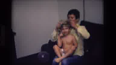 California USA (1975): Woman Putting Warm Clothing On Her Son Sitting In The