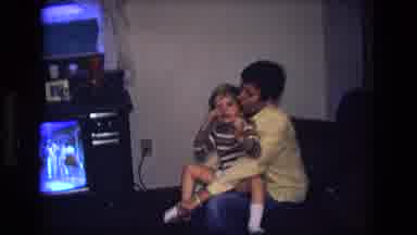 California USA (1975): Vintage Video Of Mom Dressing Male Child In Front Of Tv