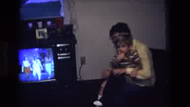 California USA (1975): A Mother Engaged With A Kid Changing His Clothes While