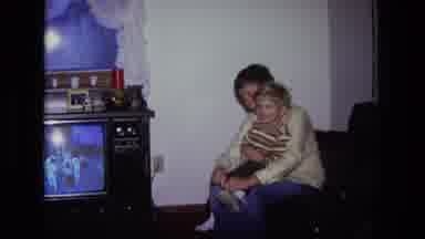 California USA (1975): Vintage Mother With Son On Lap Putting On His Shoes