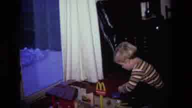 California USA (1975): Boy Wearing Brown Striped Shirt Plays With Mcdonald's