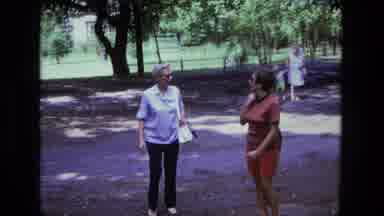 California USA (1975): Two Ladies Walking And Talked No Outside In A Park Carrying