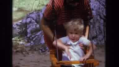 California USA (1975): Mother Helps Toddler Into The Swing And Later Toddler Plays