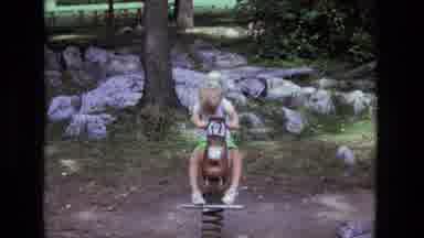 California USA (1975): Little Boy Rocking Back And Forth On A Spring Mounted Horse