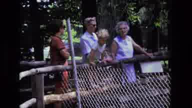 California USA (1975): Family Looks Over Rails Of Bridge That Crosses A Small
